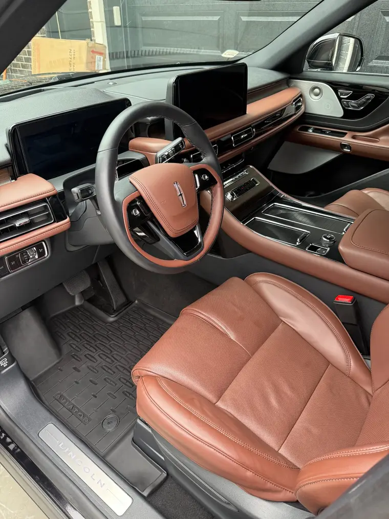 Black Lincoln Aviator brown leather driver seat and clean floor mat after a mobile interior detail by A&F Auto Detailing in Shelby Township, MI