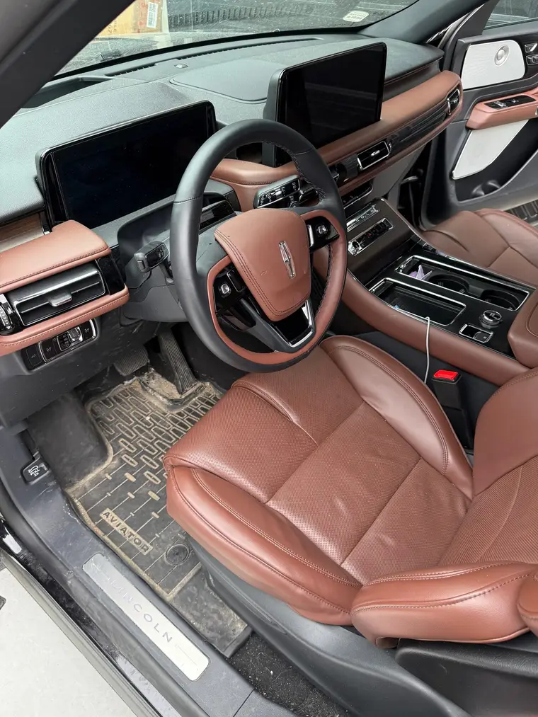 Black Lincoln Aviator driver seat and muddy floor mat before a mobile interior detail by A&F Auto Detailing in Shelby Township, MI